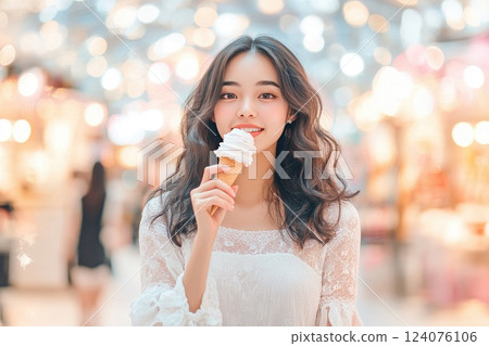 Young woman enjoying ice cream in a lively market during evening hours with soft bokeh lights in the background 124076106