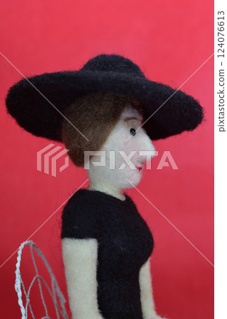 A female doll wearing a hat and sitting on a chair A female doll wearing a hat and sitting on a chair 124076613