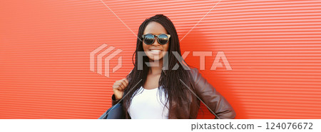 Fashionable happy young African woman with handbag in casual, stylish black girl posing in the city 124076672