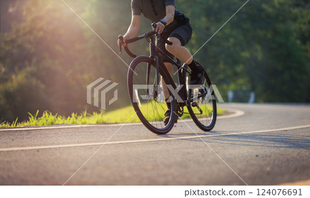 Woman cycling on summer park trail Woman cycling on summer park trail 124076691