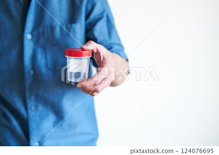 Man holding a sperm collection cup 124076695