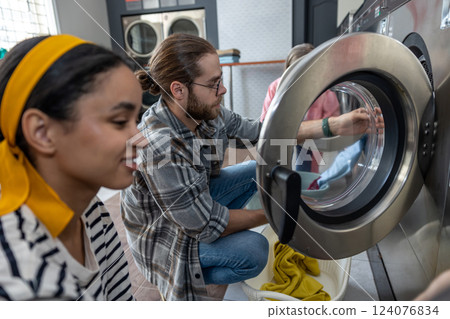 People completing their housework chores using washing machines People completing their housework chores using washing machines 124076834
