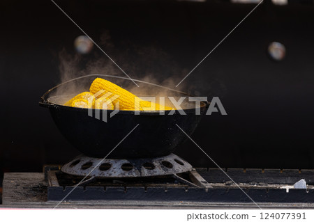 Deliciously Boiling Corn on the Cob in a Classic Black Pot, Perfectly Steaming on a Stovetop, Emitting Aromatic Scents That Tempt Any Food Lover Nearby 124077391