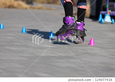 A Dynamic Moment of Inline Skating with Colorful Cones - Showcasing Skill and Balance in an Outdoor Setting A Dynamic Moment of Inline Skating with Colorful Cones - Showcasing Skill and Balance in an Outdoor Setting 124077416