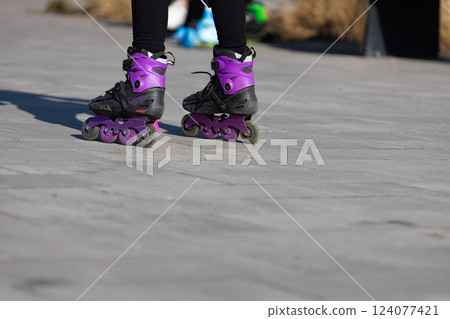 A Close-Up View of Rollerblades with Purple Accents on a Sunny Day in a Park Setting, Perfect for Exploring Outdoor Activities and Recreational Fun A Close-Up View of Rollerblades with Purple Accents on a Sunny Day in a Park Setting, Perfect for Exploring Outdoor Activities and Recreational Fun 124077421