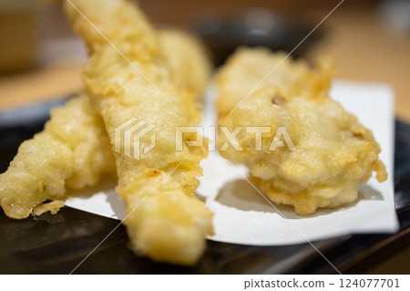 Crispy shrimp tempura with a golden, airy batter served on a black plate Crispy shrimp tempura with a golden, airy batter served on a black plate 124077701