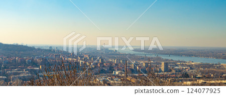 A panoramic cityscape with bridges, a winding river, and distant hills under a hazy golden sky. A panoramic cityscape with bridges, a winding river, and distant hills under a hazy golden sky. 124077925