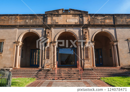Historic Albert Spencer Wilcox Memorial Building in Hawaii, featuring arched entrances, decorative columns, brick steps, and a small grassy area. Historic Albert Spencer Wilcox Memorial Building in Hawaii, featuring arched entrances, decorative columns, brick steps, and a small grassy area. 124078471