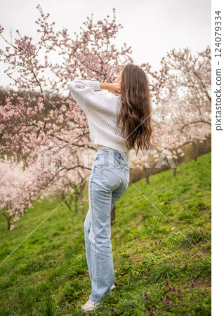 Lovely young woman in a blooming pink and white garden Petrin in Prague, spring time in Europe 124079334