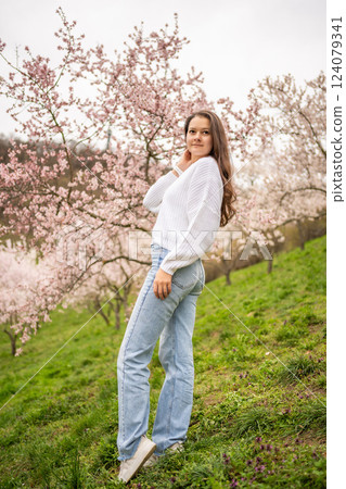 Lovely young woman in a blooming pink and white garden Petrin in Prague, spring time in Europe 124079341