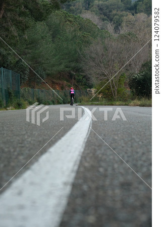 Cyclist on the roadway outside the city Cyclist on the roadway outside the city 124079582