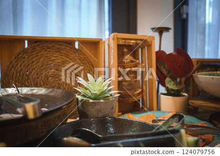 A stylish interior setting features a potted succulent, woven basket, wooden crate with birdcage, and a vibrant plant with red leaves, evoking Marrakech charm. A stylish interior setting features a potted succulent, woven basket, wooden crate with birdcage, and a vibrant plant with red leaves, evoking Marrakech charm. 124079756