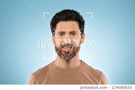 A man with a beard smiles confidently while facial recognition technology is displayed over his face. 124080820