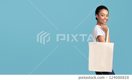 Eco Bag. Afro Woman Holding White Blank Canvas Tote Handbag Shopper Standing Over Turquoise Studio Background. Panorama, Free Space 124080828