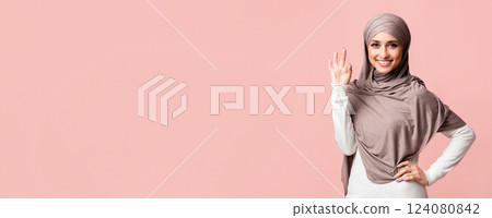 Recommended. Smiling muslim woman in hijab showing ok sign gesture, posing over pink background and looking at camera, free space Recommended. Smiling muslim woman in hijab showing ok sign gesture, posing over pink background and looking at camera, free space 124080842