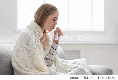 Covid-19 infection. Sick young woman coughing at home, empty space Covid-19 infection. Sick young woman coughing at home, empty space 124081020