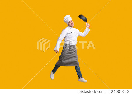 Funny Chef Guy Jumping Holding Frying Pan Having Fun Posing In Studio Over Yellow Background. Copy Space, Full Length Funny Chef Guy Jumping Holding Frying Pan Having Fun Posing In Studio Over Yellow Background. Copy Space, Full Length 124081030