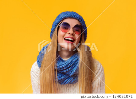 Beautiful blonde woman in winter set and sunglasses laughing over pink background, copy space 124081071