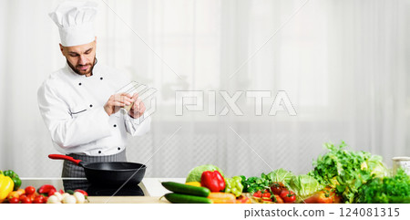 Cooking Food Concept. Professional Chef Adding Pepper In Frying Pan Seasoning Dish Standing In Kitchen Indoor. Selective Focus Cooking Food Concept. Professional Chef Adding Pepper In Frying Pan Seasoning Dish Standing In Kitchen Indoor. Selective Focus 124081315
