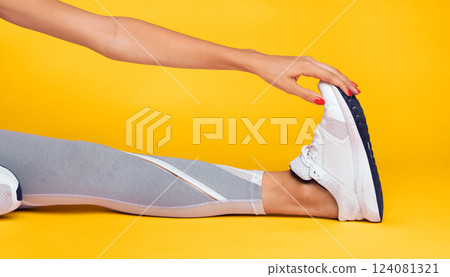 Unrecognizable Girl Stretching Leg Sitting On Floor During Fitness Workout Over Pink Studio Background. Cropped Unrecognizable Girl Stretching Leg Sitting On Floor During Fitness Workout Over Pink Studio Background. Cropped 124081321