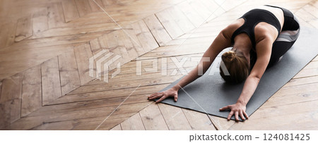 Peace, balance, harmony concept. Blonde girl laying face down on yoga mat at studio, stretching, copy space Peace, balance, harmony concept. Blonde girl laying face down on yoga mat at studio, stretching, copy space 124081425
