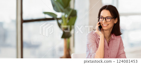 Business Call. Happy woman in specs talking on mobile phone, consulting client, using laptop and looking aside copyspace 124081453