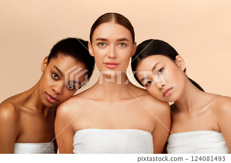 Body Care. Three Diverse Girls Models Wrapped In Towels Posing Looking At Camera Over Beige Background. Studio Shot 124081493