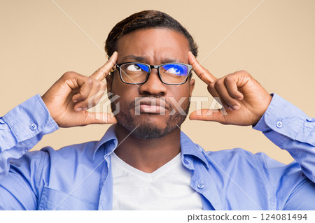 Creative Thinking. Thoughtful Black Man Concentrating Hard On An Idea Pointing Fingers At Forehead Standing On Yellow Background 124081494