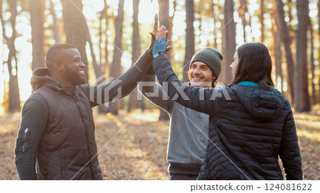 Cheerful multiracial friends gathering hands up together over camping tent, teamwork concept Cheerful multiracial friends gathering hands up together over camping tent, teamwork concept 124081622
