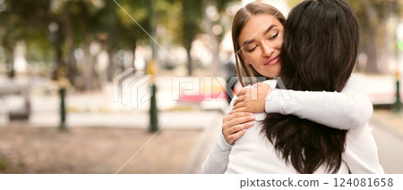 Lousy Friend. Sly Girl Embracing Desperate Girlfriend Pretending To Support Her Standing Outside. Lousy Friend. Sly Girl Embracing Desperate Girlfriend Pretending To Support Her Standing Outside. 124081658