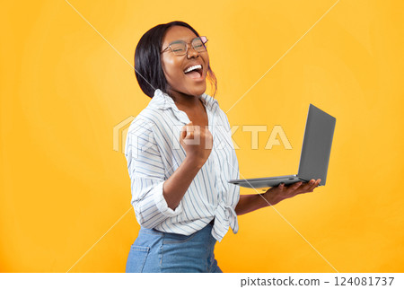 Good News. Excited Afro Girl Holding Laptop Computer Gesturing Yes Standing Over Pink Background. Studio Shot 124081737