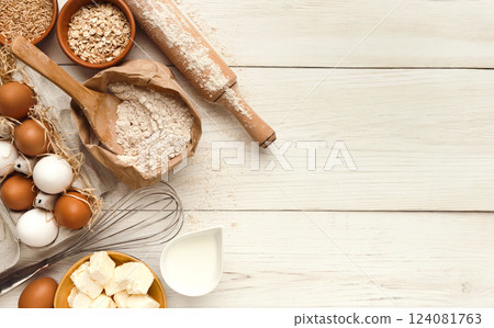 Cooking ingredients background. Border of flour, eggs, raisins, sugar, milk, butter and kitchen utensils on white rustic wood with copy space. Dough preparing and pastry concept, top view Cooking ingredients background. Border of flour, eggs, raisins, sugar, milk, butter and kitchen utensils on white rustic wood with copy space. Dough preparing and pastry concept, top view 124081763