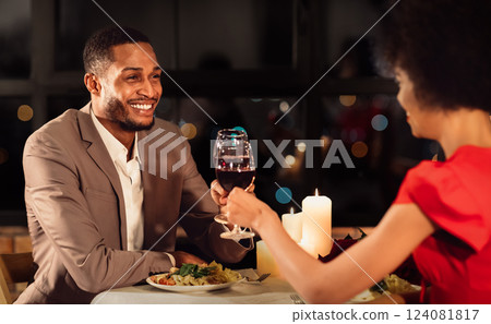 Romantic Date Concept. Loving Afro Spouses Clinking Red Wine Glasses Celebrating Anniversary Of Marriage In Fancy Restaurant. Selective Focus 124081817