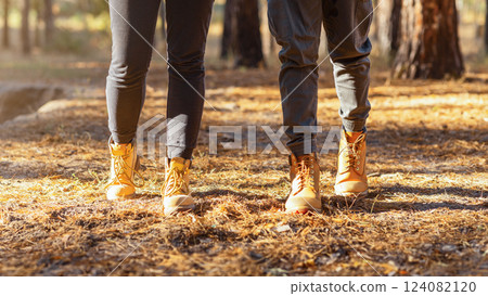 Hiking together. Couple of tourists crossing forest in autumn, cropped Hiking together. Couple of tourists crossing forest in autumn, cropped 124082120