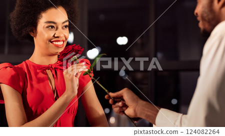 Valentine's Romance. African American Man Giving Rose To Girlfriend Having Romantic Date In Restaurant In Evening. Panorama 124082264