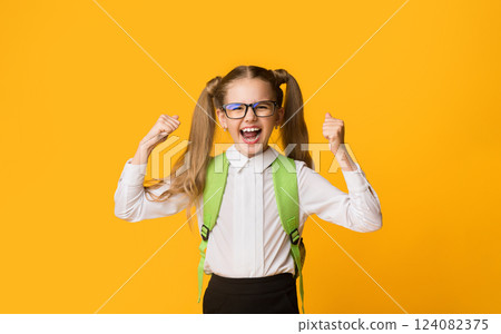 Little Winner. Cute Schoolgirl Screaming Loudly Rejoicing Success On Yellow Background. Copy Space 124082375