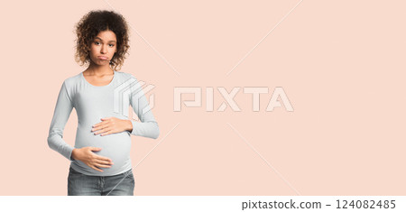 Mood changes. Sad black pregnant woman posing to camera over white background 124082485