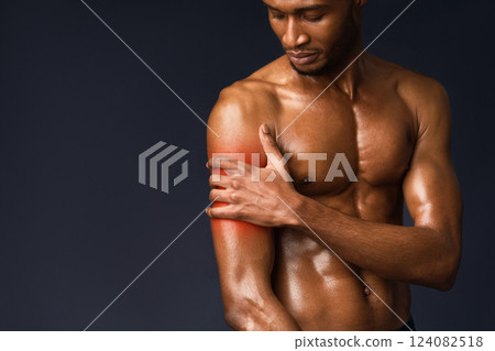 Pain In The Shoulder. Muscular black bodybuilder touching hand with red sore zone, sports injury, copyspace 124082518