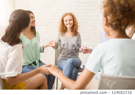 Women's Recovery Group. Diverse Girls Smiling Holding Hands Sitting In Circle Indoor. Selective Focus Women's Recovery Group. Diverse Girls Smiling Holding Hands Sitting In Circle Indoor. Selective Focus 124082538