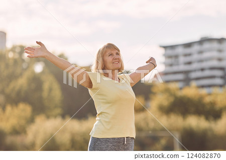 Standing and enjoying the life. Senior woman having nice weekend outdoors on the field at sunny day Standing and enjoying the life. Senior woman having nice weekend outdoors on the field at sunny day 124082870