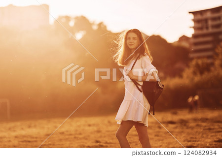 Having a walk. Young girl is on the field at sunny daytime having nice weekend 124082934