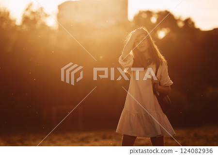 Warm weather. Young girl is on the field at sunny daytime having nice weekend 124082936