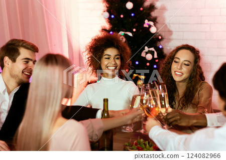 Christmas Dinner. Happy Young People Clinking Glasses Celebrating Xmas Or New Year Holidays Sitting At Celebratory Table At Home. Christmas Dinner. Happy Young People Clinking Glasses Celebrating Xmas Or New Year Holidays Sitting At Celebratory Table At Home. 124082966