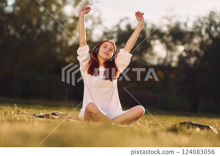 Young girls is enjoying the music. On the field at sunny daytime having nice weekend Young girls is enjoying the music. On the field at sunny daytime having nice weekend 124083056
