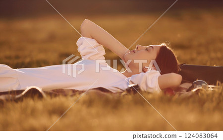 Illuminated by sunlight. Young girl is on the field at daytime having nice weekend Illuminated by sunlight. Young girl is on the field at daytime having nice weekend 124083064