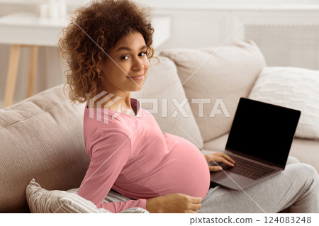 Afro expectant woman using laptop with blank screen, surfing net or buying goods for newborn 124083248