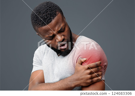 Young afro guy rubbing his itching forearm over white background, having rash 124083306