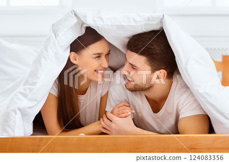 Loving Couple Talking Lying Covered With Blanket In Bed At Home. Selective Focus Loving Couple Talking Lying Covered With Blanket In Bed At Home. Selective Focus 124083356