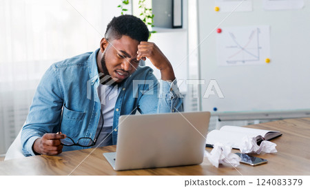 Creativity crisis. Stressed employee sitting at workplace and looking to laptop screen, unable to finish work or financial report till deadline 124083379