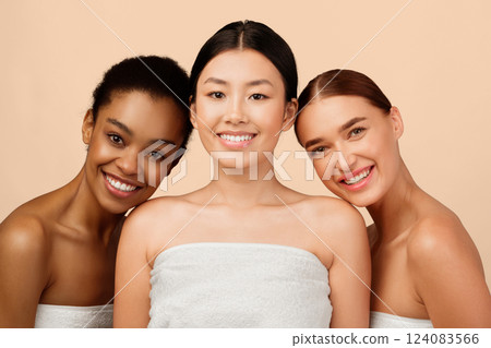 Female Beauty Concept. Three Mixed Girls Wrapped In Towels Smiling To Camera Posing In Studio On White Background. 124083566